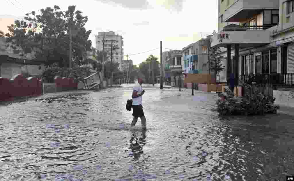  Un hombre camina por una calle inundada hoy, martes 24 de enero de 2017, en La Habana (Cuba).