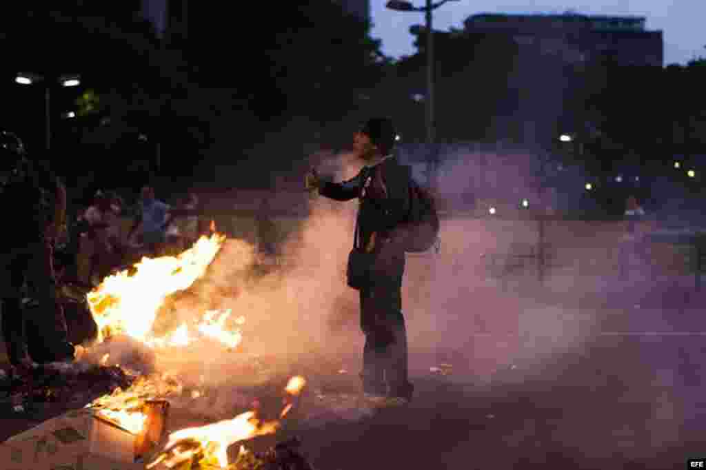 Un grupo de manifestantes quema basura en la plaza Altamira de Caracas. Al menos dos muertos, 23 heridos y más de 25 detenidos es el saldo que de momento arroja la jornada de protestas que se registró hoy en Venezuela, según fuentes oficiales.