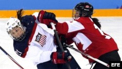 Catherine Ward (d), de la selección de Canadá, lucha por el disco con la estadounidense Hilary Knight (i) durante el partido Canadá-Estados Unidos.