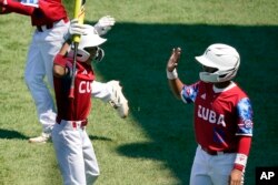 Edgar Torrez, izq., y Keybel Escalona (10) de Cuba celebran después de derrotar a Australia 11-1 Foto AP/Tom E. Puskar