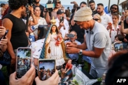 Luis Manuel Otero Alcantara junta las piezas de una virgen rota, en la Ermita de la Caridad, en Miami.