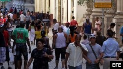 Varias personas caminan por una céntrica calle, junto a una Casa de Cambio, en La Habana (Cuba). 