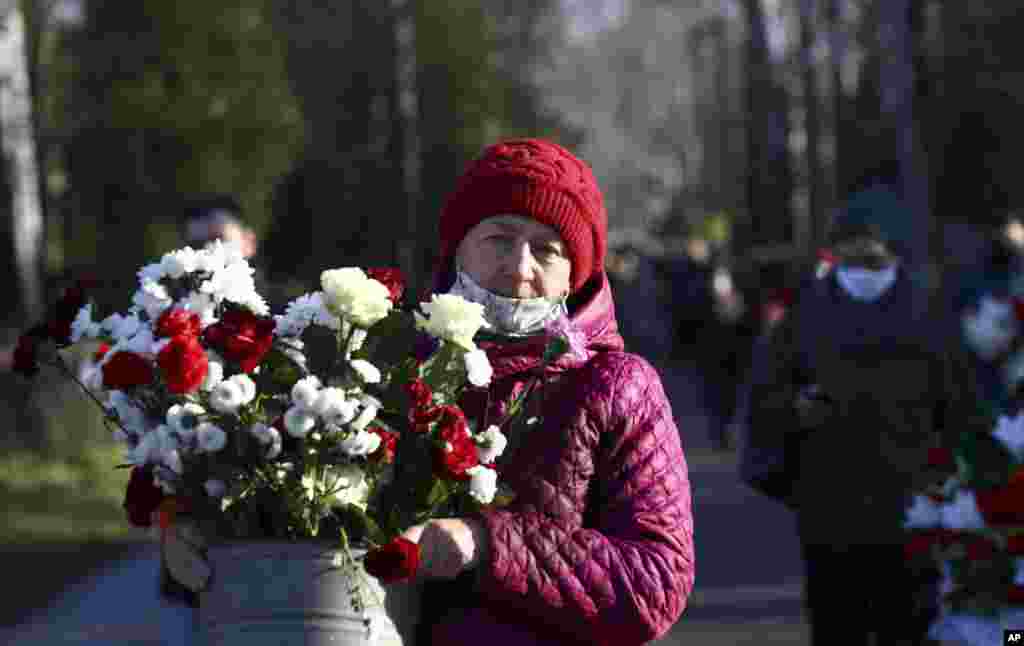 Personas llevan flores para rendir tributo a las víctimas de las protestas en Minsk, Bielorrusia.