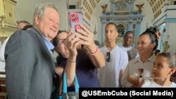 Mike Hammer junto a residentes en la Iglesia de Nuestra Señora de Regla.