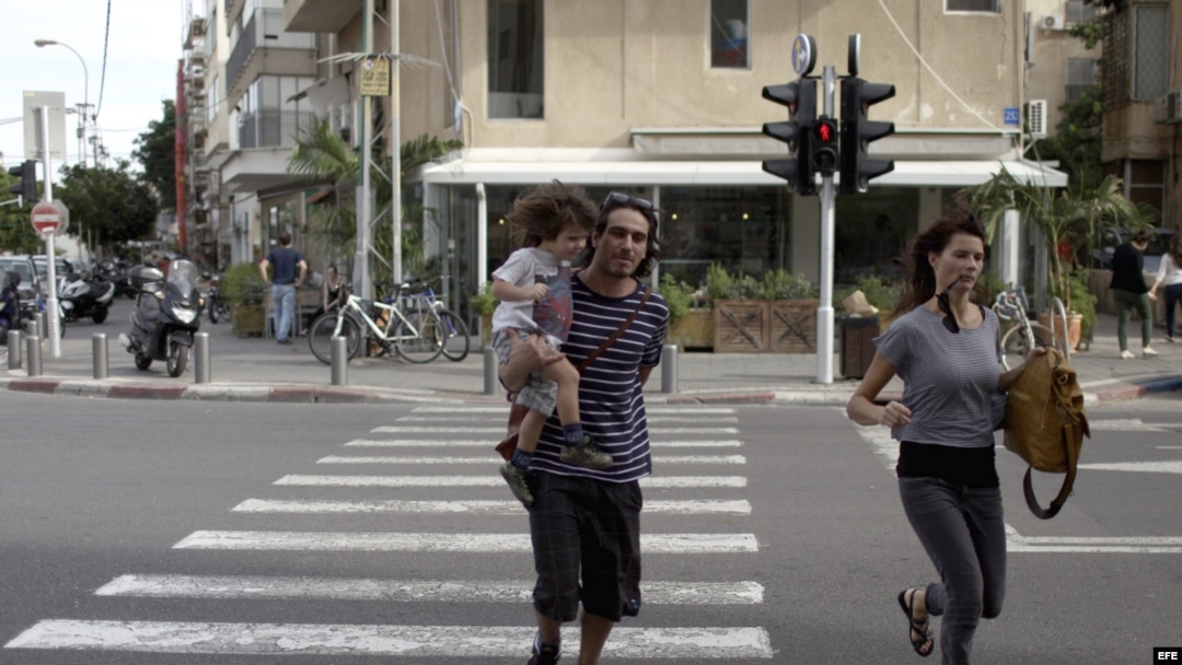 Una pareja israelí corre tras escuchar las sirenas de alarma en Tel Aviv, Israel. Archivo. 