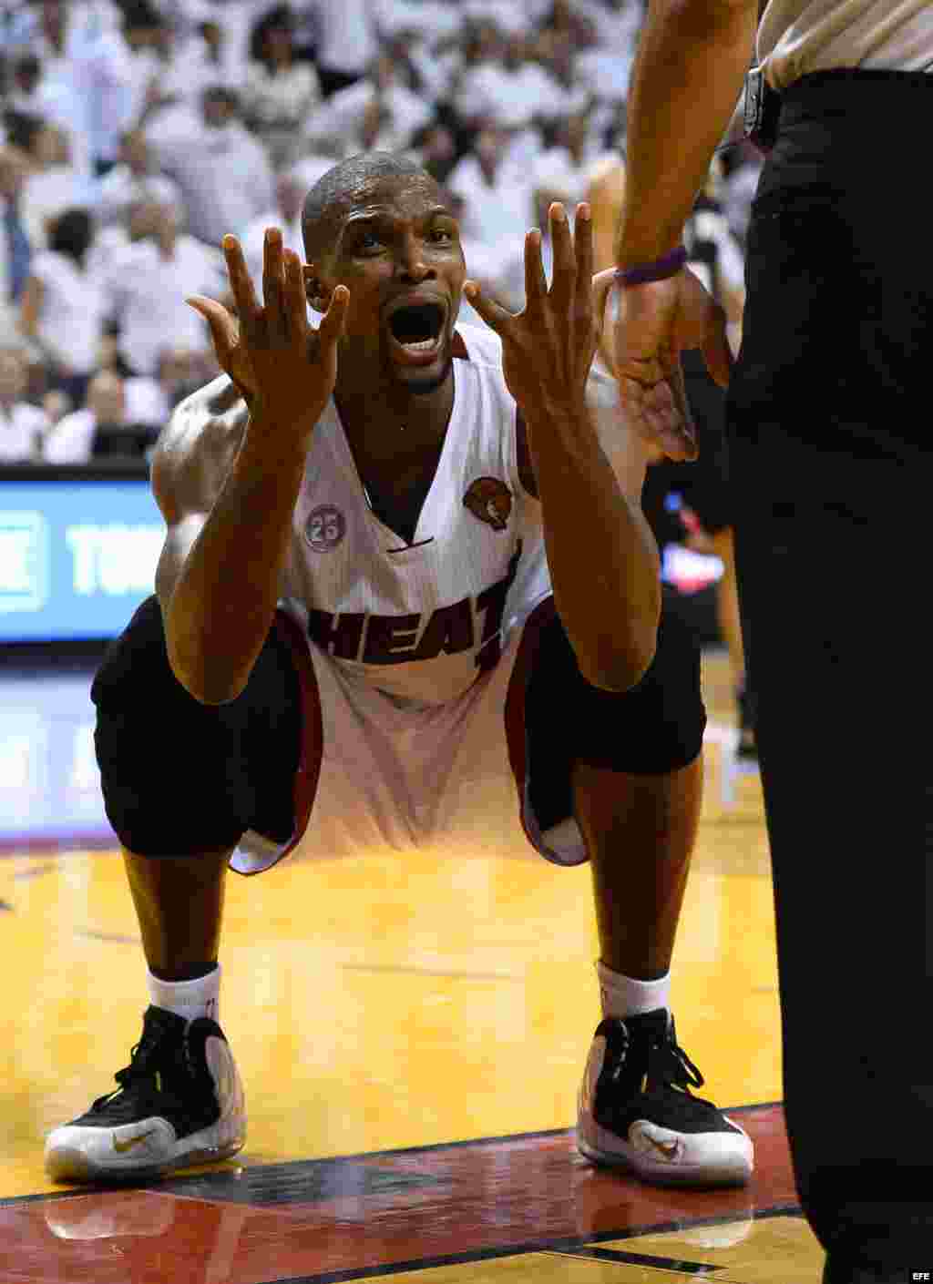 El jugador de Heat Chris Bosh (i) discute una jugada durante el partido definitivo ante Spurs.