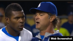 Yasiel Puig (i) es aconsejado por el mánager de los Dodgers, Don Mattingly (d).