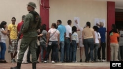Votantes venezolanos hacen cola ante un colegio electoral