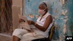 Una señora lee la prensa en la calle.