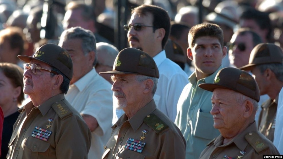 Raúl Castro con su hijo y nieto al fondo. 