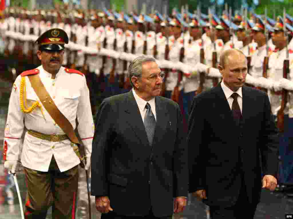 Raúl Castro (2-i) y su homólogo de Rusia Vladimir Putin (d), pasan revista a las tropas formadas en el Palacio de la Revolución de La Habana (Cuba)