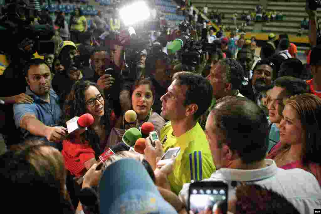 El candidato presidencial de la oposici&oacute;n a la presidencia de Venezuela, Henrique Capriles (c), habla con la prensa viernes 12 de abril de 2013, al finalizar un partido de baloncesto junto a periodistas deportivos.