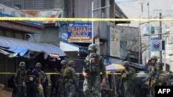 Policías y soldados se despliegan en el lugar del atentado en el templo Jolo, en Filipinas. 