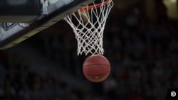 Primer plano de un balón de baloncesto cerca de la canasta