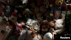 Se colocan juguetes y flores en un memorial improvisado creado por familiares de las víctimas de los terremotos del 24 de junio en Tanaguarena, La Guaira, Venezuela