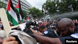 Los agentes de la policía del Capitolio de los Estados Unidos usan spray de pimienta contra los manifestantes pro palestinos mientras los empujan hacia atrás, el día en que el primer ministro israelí, Benjamin Netanyahu, se dirige a una reunión conjunta del Congreso, en Capitol Hill, Washington, Estados Unidos, el 24 de julio de 2024. REUTERS/Umit Bektas