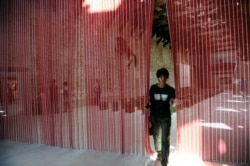 Un visitante recorre "Untitled ( Blood) " de Félix González-Torres en Punta della Dogana, Venecia.
