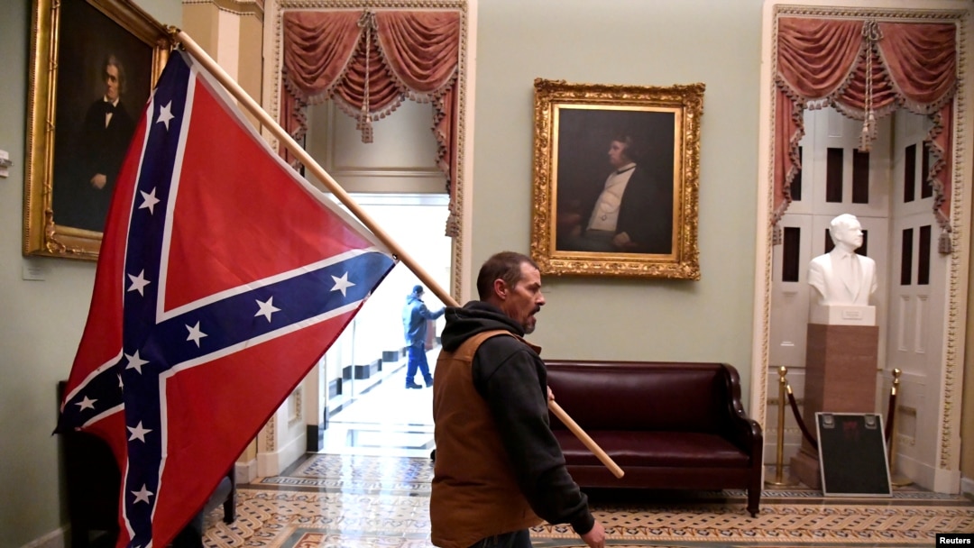 Un simpatizante del presidente Donald Trump porta una bandera confederada en el segundo piso del Capitolio, el 6 de enero de 2021. (Mike Theiler/Reuters).