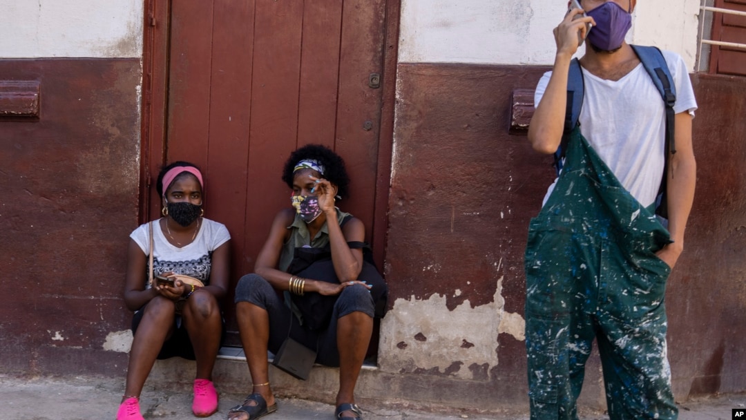 Las personas usan máscaras durante la pandemia de COVID-19 afuera de una tienda de comestibles donde esperan que abra en La Habana. (AP Foto/Ramón Espinosa) 