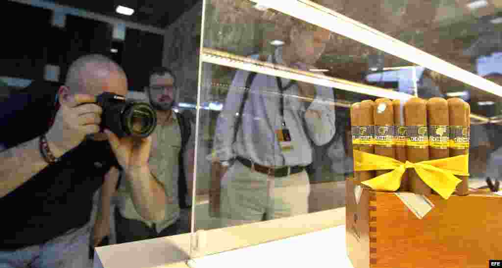 Un hombre toma fotos a unos tabacos exhibidos en el stand de Cohiba, en el Festival del Habano.