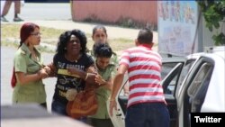 Agentes de la policía política arrestan a Berta Soler este jueves, cuando salía de la sede de las Damas de Blanco, en Lawton, La Habana. (Foto: Angel Moya)