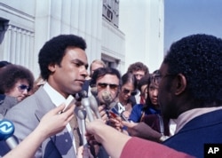 El ex líder de los Panteras Negras, Huey Newton, habla con los periodistas frente al juzgado de Oakland, California, el 7 de marzo de 1979. (Foto AP/Sal Veder)