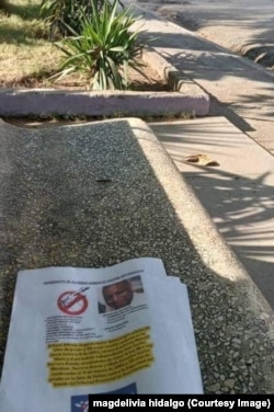 Cartel mostrando el rostro de un represor en un banco del parque principal de Guantánamo.