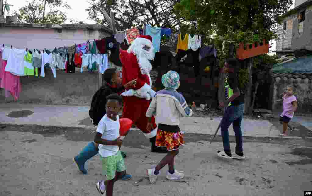 Un hombre vestido como Papá Noel camina por una calle de La Habana, el 21 de diciembre de 2023. (Foto de Yamil LAGE / AFP)