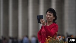 Una mujer filma con su teléfono inteligente en Corea del Norte.