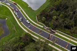 Un socavón en una carretera dañada por el huracán Milton, el viernes 11 de octubre de 2024, en Riverview, Florida. (Foto AP/Julio Cortez)