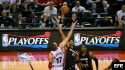 Jonas Valanciunas (17) en acción ante Hassan Whiteside (c) de Miami Heat.