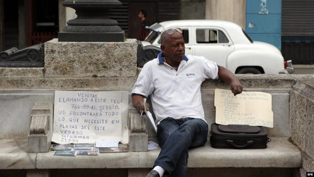 Un hombre ofrece varias casas en venta sentado en un parque hoy, lunes 12 de noviembre de 2012, en La Habana (Cuba).