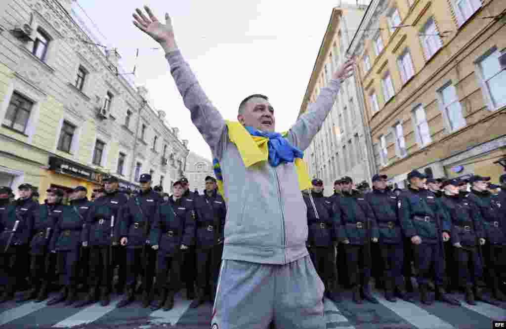 Frente a la policía de Moscú con la bandera de ucrania al cuello.