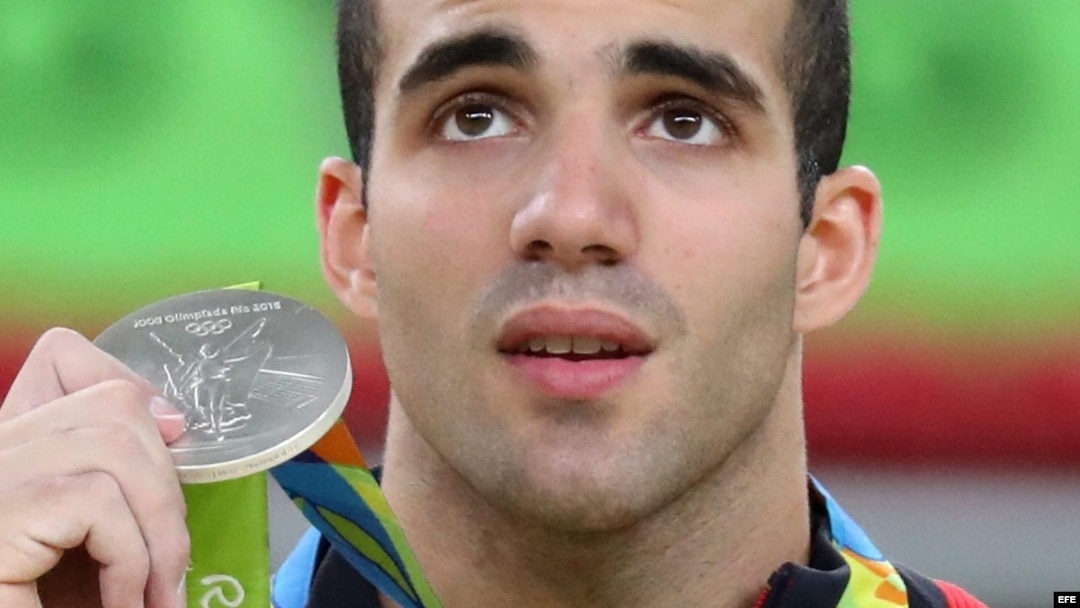 Danell Leyva muestra la medalla de plata que ganó hoy en el evento de barras paralelas en Río 2016