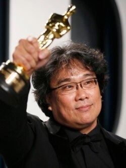 Bong Joon Ho sostiene en alto la estatuilla del Oscar por "Parasite". REUTERS/Danny Moloshok