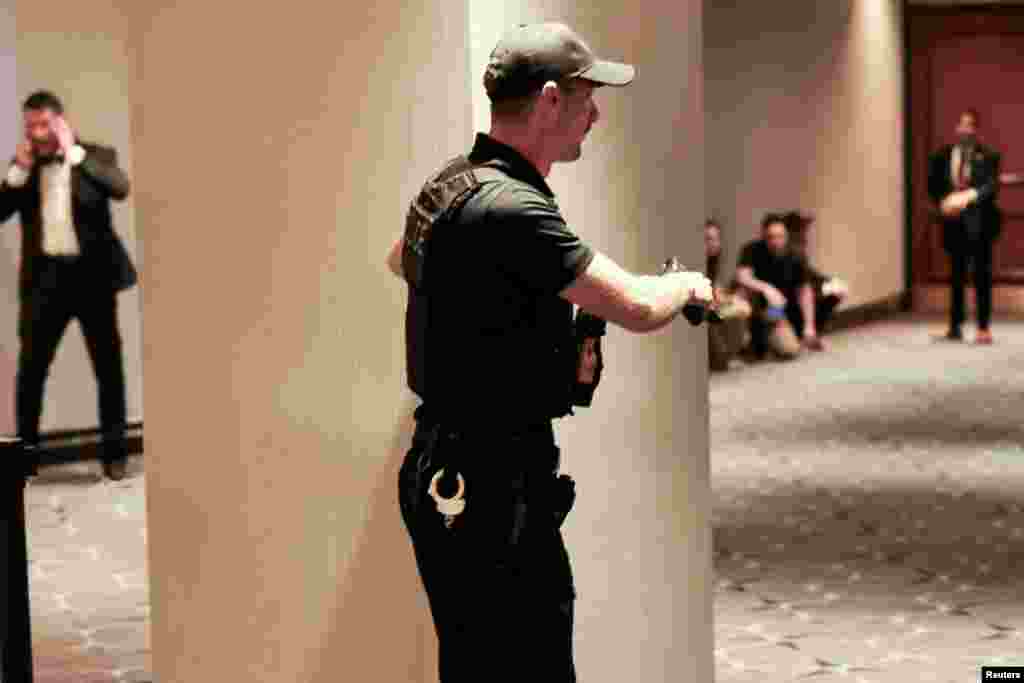 Un agente del Servicio Secreto sostiene su arma durante la evacuación de los asistentes a la cena de correpsonsales de la Casa Blanca tras escucharse disparos. 