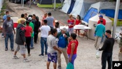 Migrantes en un campamento temporal a las afueras de El Puente Nuevo, en Matamoros, México. (Denise Cathey/The Brownsville Herald vía AP)