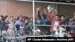 En esta foto del 27 de marzo de 2019, migrantes centroamericanos esperan comida en una estructura erigida por la Oficina de Control de Aduanas y Fronteras de EE. UU. para procesar la oleada de familias migrantes y menores no acompañados en El Paso, Texas. Foto: AP / Cedar Attanas