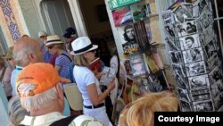 Turistas buscan postales y libros sobre el comunista Ernesto "Che" Guevara, en Trinidad, Cuba.