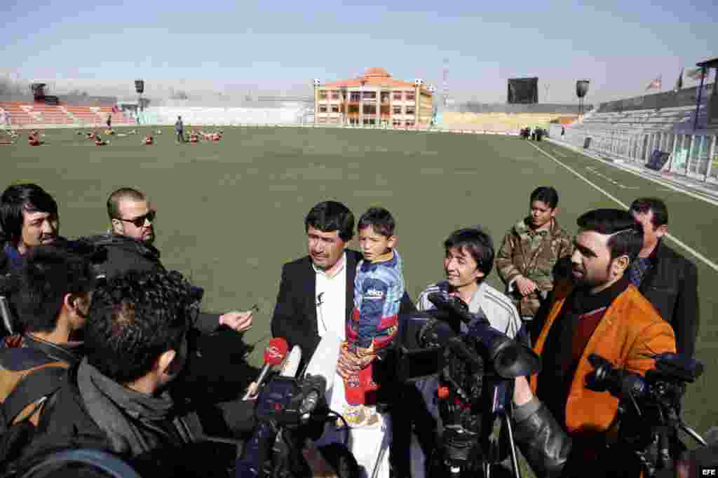 El niño afgano de 5 años Murtaza Ahmadi posa en los brazos de su padre, Muhammad Arif Ahmadi, en un campo de fútbol de Kabul, Afganistán.