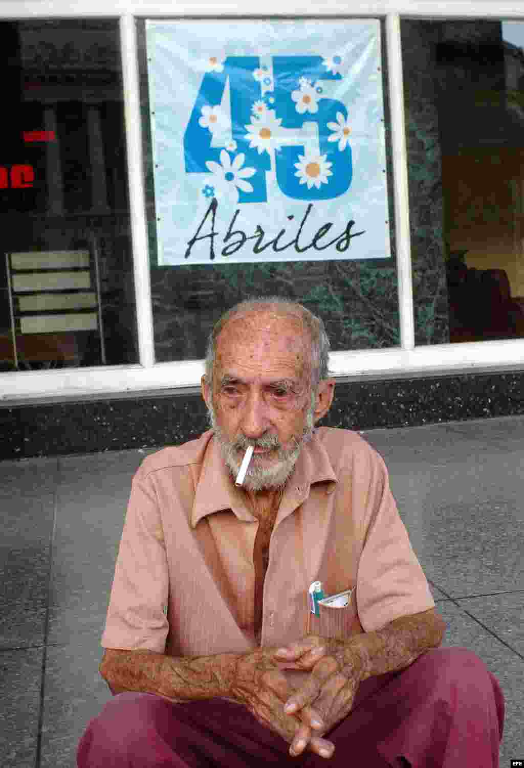 Un anciano fuma sentado en un portal en el populoso barrio de Centro Habana. La franja de edad entre los 40 y los 50 años es en la que se contabilizan más fumadores habituales, la media de edad para iniciarse en el tabaco son los 17 años y ha disminuido la brecha de la prevalencia del tabaquismo entre niñas y niños.