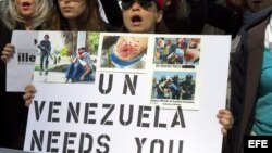 Decenas venezolanos protestan con pancartas y fotografías de personas agredidas por la Policía venezolana frente a la sede de la ONU en New York. 