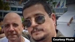 Rogelio Bolufé junto a Carlos Lazo, jefe de la agrupación pro castrista "Puentes de Amor".