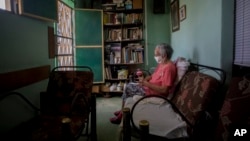 FOTO ARCHIVO. Una anciana en la sala de su casa en Cuba espera recibir un remedio homeopático como medida de protección contra el coronavirus, en mayo de 2020. (AP Photo/Ismael Francisco)