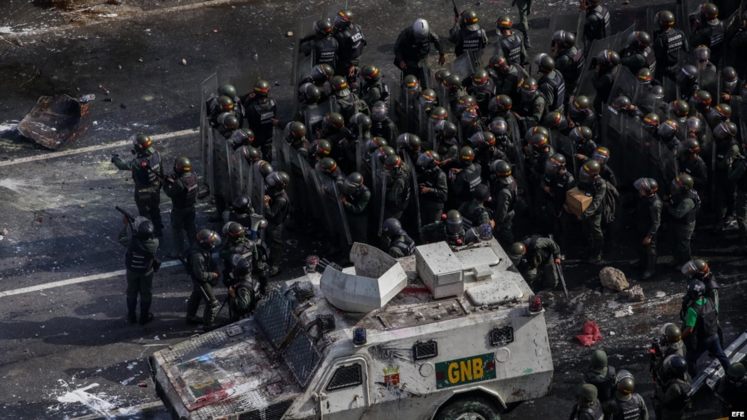 Miembros de la Guardia Nacional Bolivariana (GNB) se enfrentan a manifestantes opositores el sábado, 27 de mayo de 2017, en Caracas.