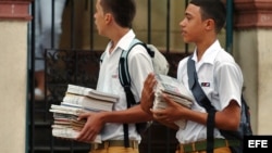 Dos estudiantes caminan con sus libros.