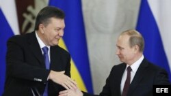 El presidente ruso, Vladímir Putin mientras estrecha la mano de Viktor Yanukovich el pasado 13 de diciembre de 2013.