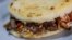 Arepa rellena de carne y tocineta, alimento típico venezolano en Caracas (Venezuela). 