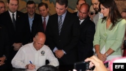 El gobernador de Florida, Rick Scott, firma la ley en mayo de 2012 en la histórica Torre de la Libertad de Miami, símbolo de los cubanos exiliados en Estados Unidos