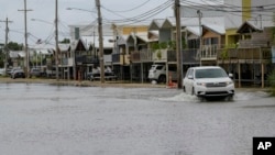 Una camioneta avanza por Breakwater Drive en Nueva Orleans, Luisiana, el viernes 12 de julio de 2019, inundada por la tormenta tropical Barry. (AP Foto/Matthew Hinton).